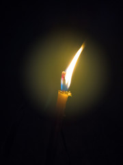 Fototapeta premium Candle flame close up on a black background