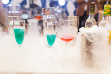 colorful cocktails in the smoke at the bar among the bottles