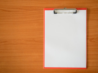 Blank paper on clipboard , on wooden floor.