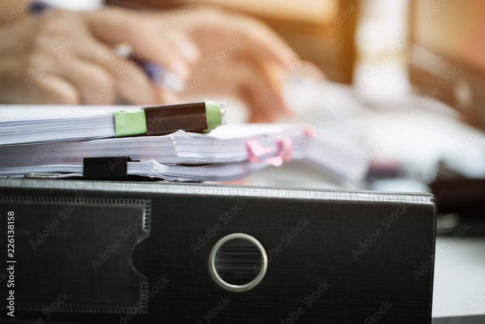 Sticker Pile of unfinished documents stack paperwork and report files on busy overwork desk with blur businessman hands working for searching information. Business and Accounting planning budget concept