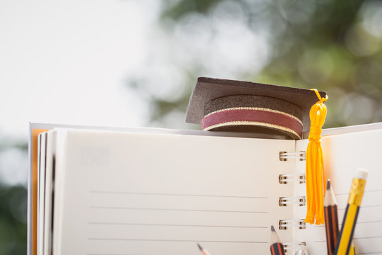 Graduated or Graduation university study abroad international Conceptual, Congratulations to graduates hat on notebook with pencils for copy space. Studies lead to success in Goal life. Back to School