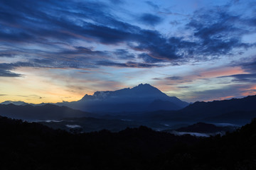 Beautiful sunrise landscape scenery with sunlight and fog and Mount Kinabalu as background in Guakon, Sabah, Malaysia