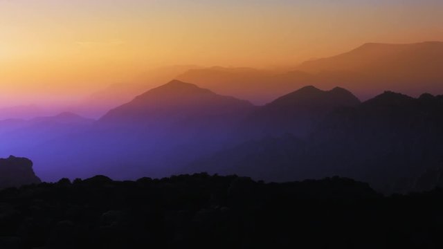 silhouette mountains with beautiful sunrise colors. Pan left. 4K