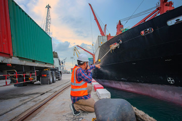 Shipment container delivery trucking to the ship in port, supervisor, harbour master, port captain working in charge of command in loading discharging containers shipment operation, at port terminal