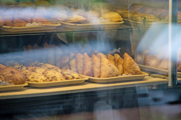 A rich variety of buns pies, donuts in a typical confectionery shop window. Baked buns in the bakery. Sweet dessert food closeup.
