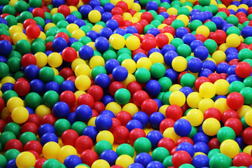 Fototapeta na wymiar Many colorful plastic balls in a kids' ballpit at a playground.