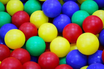 Fototapeta na wymiar Many colorful plastic balls in a kids' ballpit at a playground.