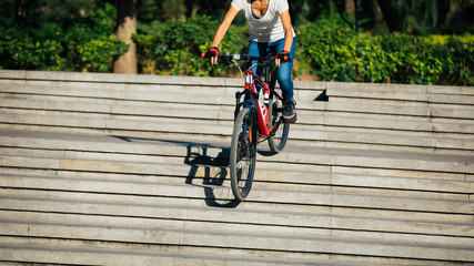 Woman freerider riding down city stairs. Sports extreme and active lifestyle