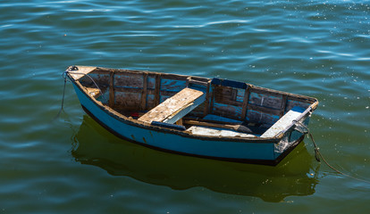 a wooden dingy or row boat in a bay