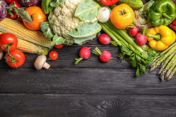 Flat lay composition with assortment of fresh vegetables on wooden table. Space for text