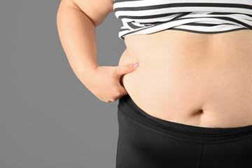 Overweight woman on gray background, closeup view