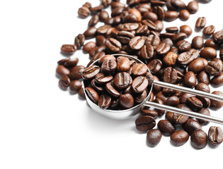 Scoop and roasted coffee beans on white background, closeup