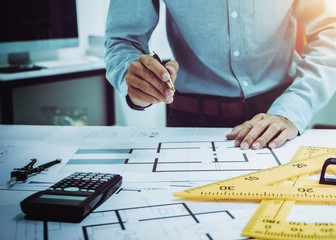Young Asian man architect working at working desk about his housing project.
