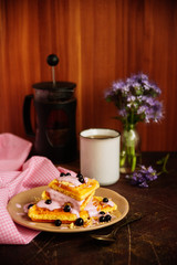 Fresh homemade Viennese waffles, drenched with yogurt and berries