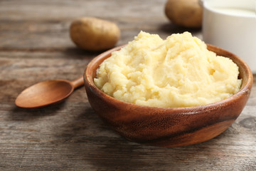 Bowl with mashed potatoes on wooden table