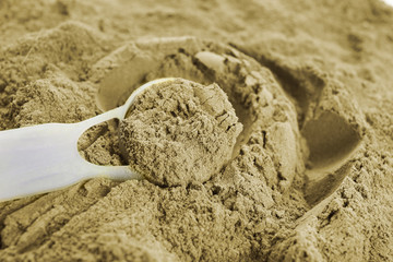 Fototapeta na wymiar Hemp protein powder and measuring scoop, closeup