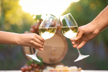Couple with glasses of white wine outdoors, closeup