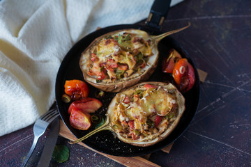 Autumn food with fresh vegetables, quick lunch: eggplant stuffed with tomatoes and cheese. The concept of healthy and vegetarian food.