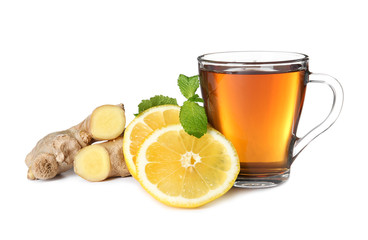 Glass cup of tea, lemon slices and ginger on white background