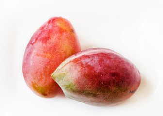 Two whole mangoes isolated on white background