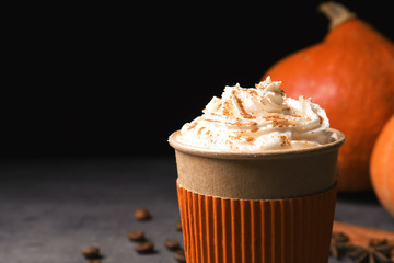 Paper cup of tasty pumpkin spice latte on gray table, closeup with space for text