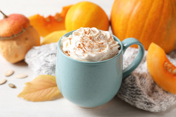 Cup with tasty pumpkin spice latte on light table