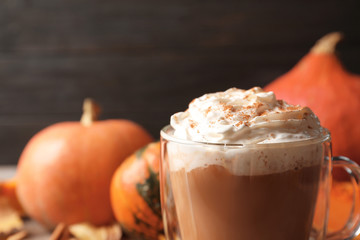 Glass cup with tasty pumpkin spice latte on table, closeup