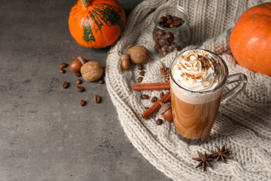 Fototapeta Glass cup with tasty pumpkin spice latte and space for text on table