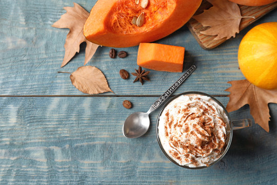 Flat lay composition with glass cup of tasty pumpkin spice latte and space for text on wooden background