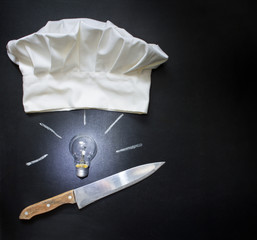 Idea for cooking food abstract concept with bulb knife and chef's hat on blackboard