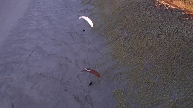 Drone/Aerial shot of a parapenter flying over the duns ot the Netherlands. Shot was made by a professional drone pilot.