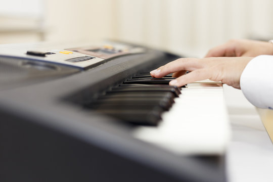 電子ピアノを弾く女性の手