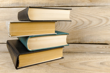 A stack of books on a wooden shelf