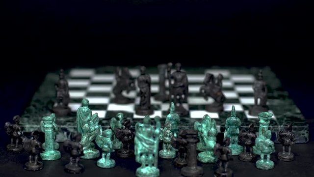 ancient marble chessboard with teal bronce knights as pawns slider macro