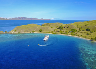 Tourist boat passing over Gili Lawa Island, aerial view. © nelzajamal