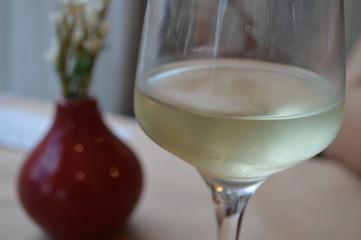 Glass of wine & Red vase with flowers