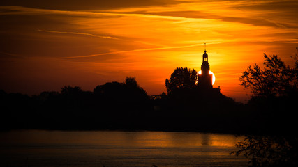 Silhouette van een kerk en dorp in de ochtend zon