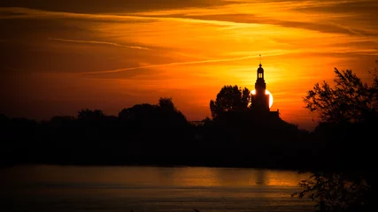 Poster Silhouette van een kerk en dorp in de ochtend zon © JoveImages