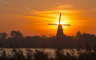 Deurstickers Silhouette van een molen in de ochtend zon © JoveImages