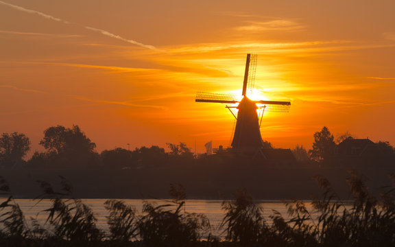 Silhouette van een molen in de ochtend zon