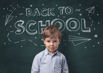 Adorable little boy with blackboard and back to school concept