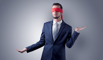 Covered eye, indecisive businessman standing blind in front of a wall