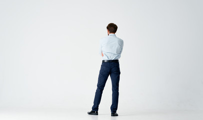 business man in shirt stands with his back to the camera on an isolated background
