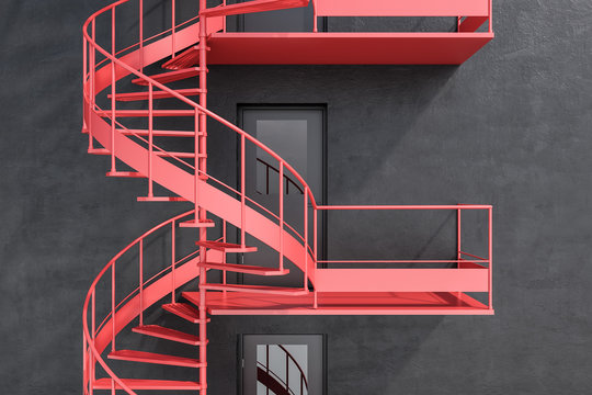 Gray building with red spiral fire escape stairs