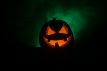 Halloween pumpkin smile and scrary eyes for party night. Close up view of scary Halloween pumpkin with eyes glowing inside at black background.