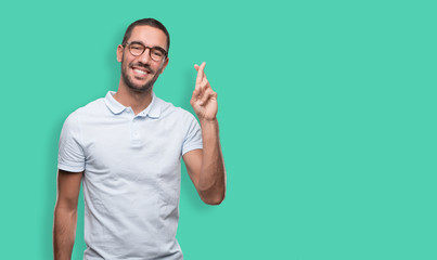 Happy young man doinga gesture of crossed fingers