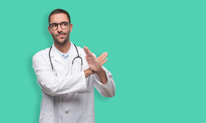 Serious young doctor doing a gesture of prohibition with his hands