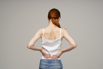 woman has a backache on a light background