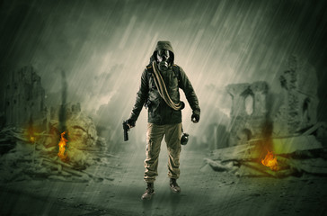 Fototapeta premium Destroyed place after a catastrophe with man in gas mask and weapon on his hand 