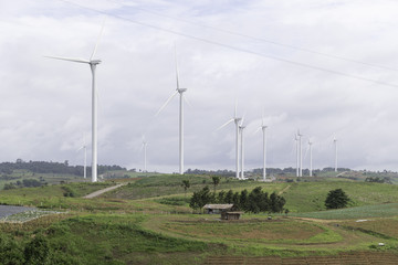 Fototapeta na wymiar Wind turbines generating electricity, landscape with hills.